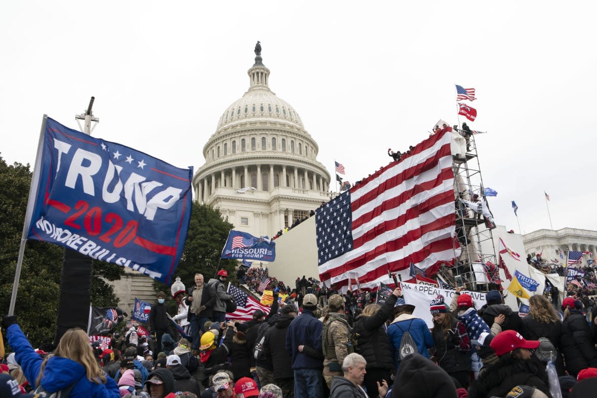 FILE – Violent insurrectionists loyal to President Donald Trump stand outside the U.S. Capitol in Washington on Jan. 6, 2021. On Monday, Dec. 19, the House select committee investigating the Jan. 6 attack on the U.S. Capitol will hold its final meeting. (AP Photo/Jose Luis Magana, File)