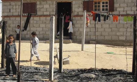 Boys look at a burnt area around a house after assaults on militant targets by the Egyptian Army, in a village on the outskirts of Sheikh Zuweid, near the city of El-Arish in Egypt's Sinai peninsula in this September 10, 2013 file photo. REUTERS/Stringer /Files