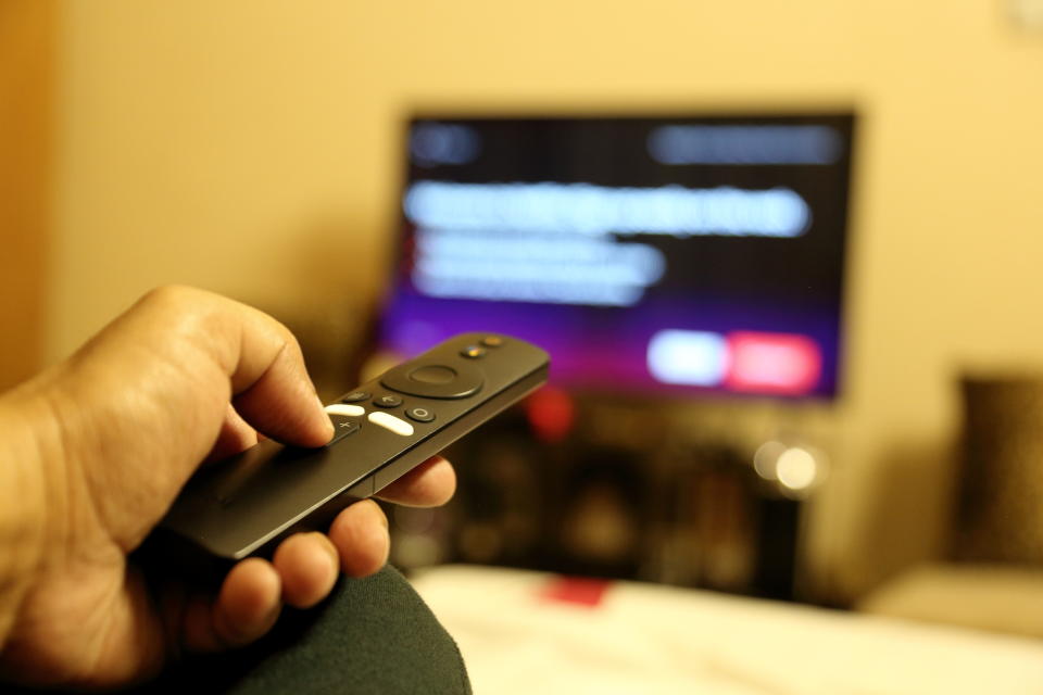 Pointing remote control towards HD TV.