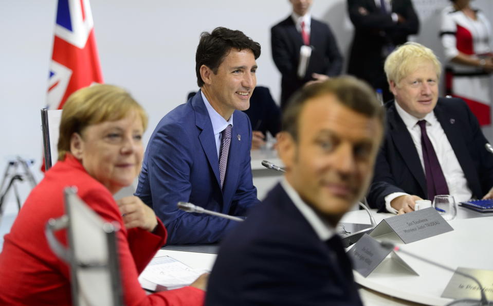 Canadian Prime Minister Justin Trudeau, second from left, German Chancellor Angela Merkel, left, President of France Emmanuel Macron, second from right, and British Prime Minister Boris Johnson take part in a working session with G7 leaders on the second day of the G-7 summit in Biarritz, France Sunday, Aug. 25, 2019. (Sean Kilpatrick/The Canadian Press via AP)