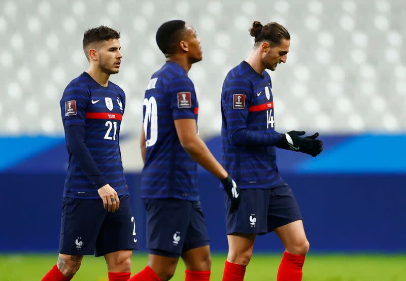 Los jugadores de la selección francesa de fútbol Adrien Rabiot, Anthony Martial y Lucas Hernandez reaccionan tras el empate 1-1 ante Ucrania por las eliminatorias al Mundial de Qatar, en el Stade de France, Saint-Denis, Francia