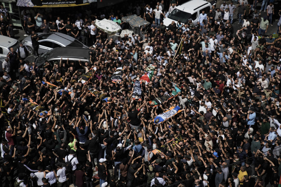 Mourners carry the bodies of Palestinians, some are draped in the Islamic Jihad militant group flags during their funeral in the West Bank city of Jenin, Thursday, May 23, 2024. The Israeli military said Thursday it has completed a two-day operation in the occupied West Bank that the Palestinian Health Ministry says killed 12 Palestinians. Militant groups claimed at least eight of the dead as fighters, one from Hamas and seven from the Al-Aqsa Martyrs Brigade. (AP Photo/Majdi Mohammed)