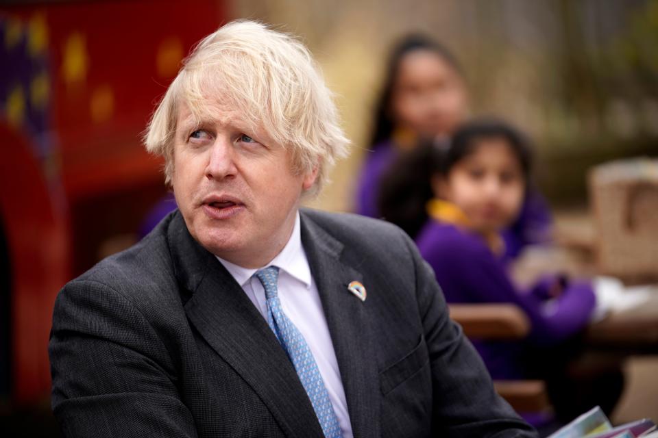 Prime Minister Boris Johnson, joins a Year 4 pupils in their reading lesson outside, during his visit to St Mary’s CE Primary School in Stoke-on-Trent, central England on 1 March, 2021. Mr Johnson’s government is furthering its efforts to combat obesity and pursuing the possibility of a ‘fit miles’ programme. (POOL/AFP via Getty Images)