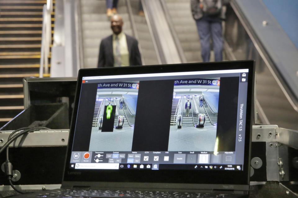 FILE - In this Tuesday, Feb. 27, 2018 file photo ThruVision suicide vest-detection technology reveals a suspicious object on a man, at left, during a Transportation Security Administration demonstration in New York's Penn Station. Los Angeles is poised to have the first mass transit system in the U.S. with body scanners that screen passengers for weapons and explosives. Officials from the Los Angeles County Metropolitan Transportation Authority and the Transportation Security Administration have scheduled a Tuesday, Aug. 14, 2018, news conference. The TSA has been working on the experimental devices, known as standoff explosive detection units, since 2004 with transit agencies. They hadn't been deployed permanently at any transit hub. (AP Photo/Richard Drew,File)