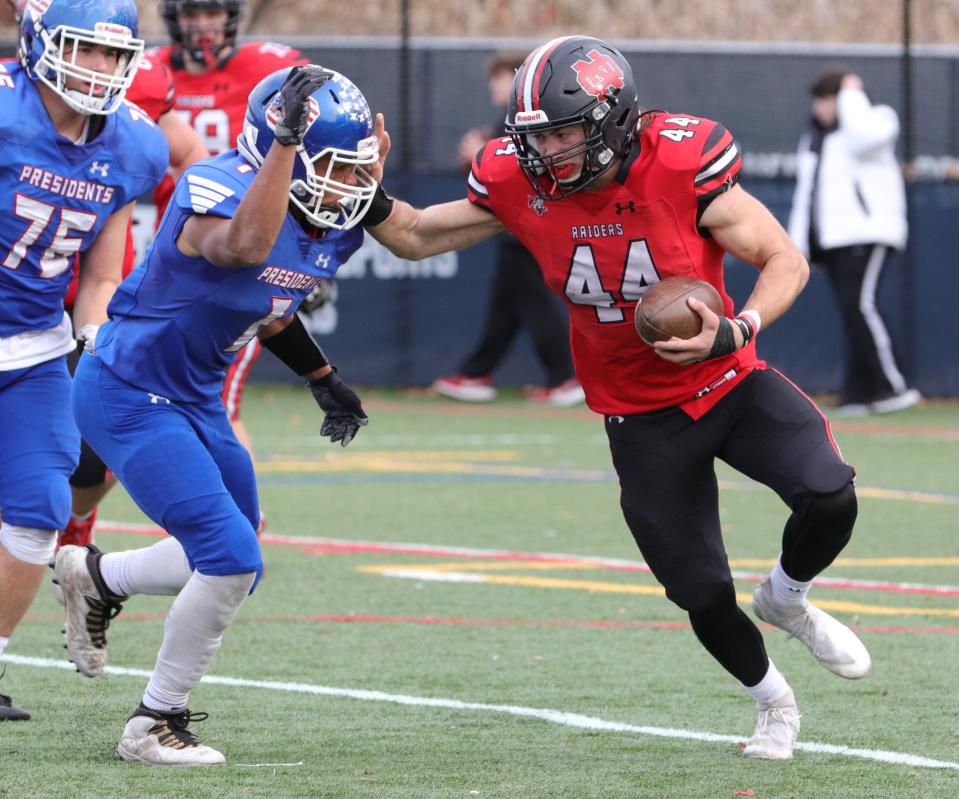 North Quincy's Matt Craig stiff-arms Jarod Walker during the 89th Thanksgiving game against Quincy at Veteran's Memorial Stadium in Quincy on Thursday, Nov. 25, 2021.