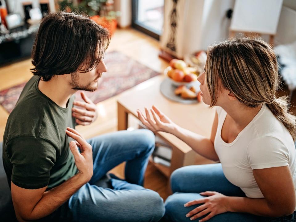 young couple arguing while sitting on the couch