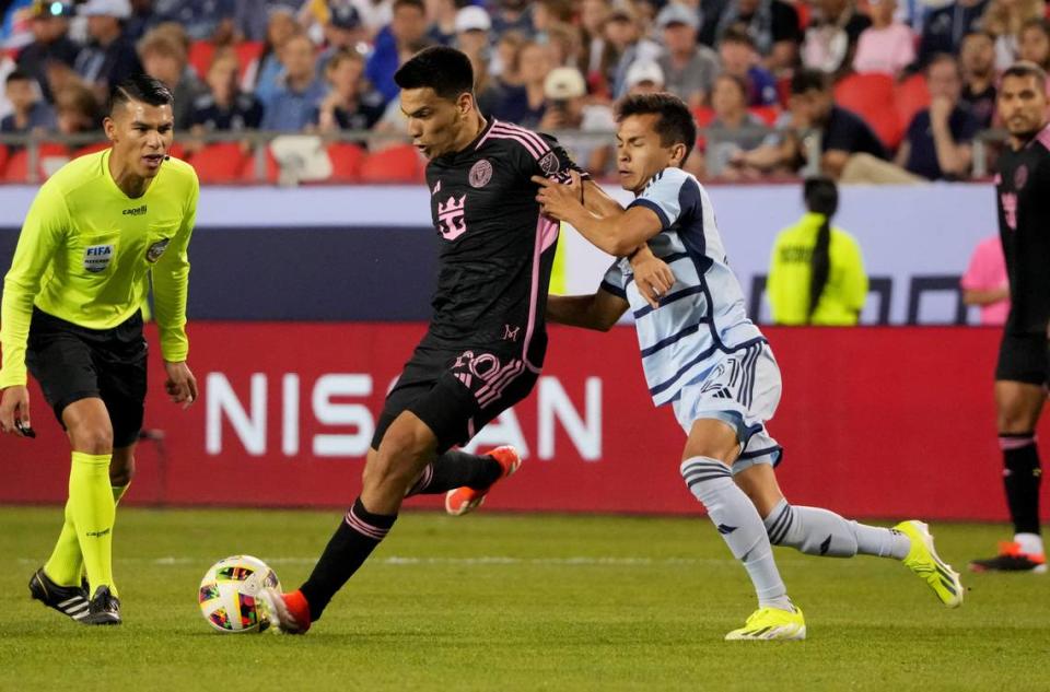 Apr 13, 2024; Kansas City, Kansas, USA; Inter Miami CF midfielder Diego Gomez (20) passes against Sporting Kansas City midfielder Felipe Hernandez (21) during the first half at GEHA Field at Arrowhead Stadium. Mandatory Credit: Denny Medley-USA TODAY Sports