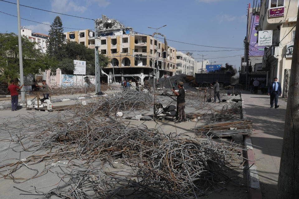 Palestinian workers recycle metal iron rods from the rubble of the Al-Jawhara building, which was damaged by Israeli airstrikes during Israel's war with Gaza's Hamas rulers last May, in the central of al-Rimal neighborhood of Gaza City, Dec. 5, 2021. The Gaza Strip has few jobs, little electricity and almost no natural resources. But after four bruising wars with Israel in just over a decade, it has lots of rubble. Local businesses are now finding ways to cash in on the chunks of smashed concrete, bricks and debris left behind by years of conflict. (AP Photo/Adel Hana)