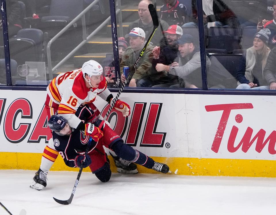 Columbus Blue Jackets right wing Oliver Bjorkstrand (28) gets tangled up with Calgary Flames defenseman Nikita Zadorov (16) during the second period of the NHL hockey game at Nationwide Arena in Columbus on Wednesday, Jan. 26, 2022. 