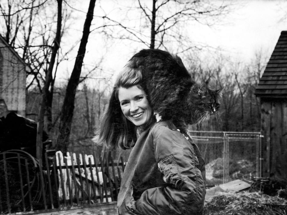 Caterer Martha Stewart outside in backyard with her pet persian cat perched on her shoulder, 24th March 1980.