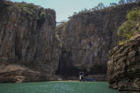 A tourist boat navigates through a canyon in Furnas Lake, near Capitolio City, Brazil, Sept. 2, 2021. A massive slab of rock broke away on Saturday, Jan. 8, 2022, from the canyon wall and and toppled onto pleasure boaters killing at least two people and injuring dozens at the popular tourist destination in Minas Gerais state. (AP Photo/Andre Penner)