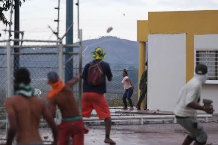 Protesters hurl stones at a guard post at the border between Venezuela and Brazil in Pacaraima, Brazil February 23, 2019. REUTERS/Ricardo Moraes