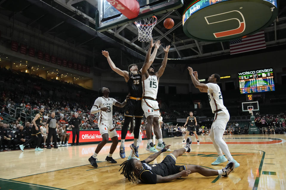 Miami forward Norchad Omier (15) jumps for a rebound against La Salle forward Rokas Jocius (35) during the first half of an NCAA college basketball game, Saturday, Dec. 16, 2023, in Coral Gables, Fla. (AP Photo/Rebecca Blackwell)