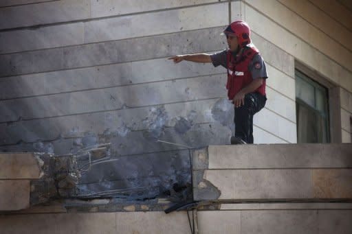 An Israeli fireman inspects damage in the southern Israeli city of Beersheva on August 21, following a day of Palestinian rocket attacks on southern Israel and Israeli air raids on the Gaza Strip. An Israeli air strike killed a Palestinian militant and wounded another in the Gaza Strip, witnesses and their organisation