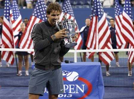 Rafael Nadal of Spain bites his trophy after defeating Novak Djokovic of Serbia in their men's final match at the U.S. Open tennis championships in New York, September 9, 2013. REUTERS/Mike Segar