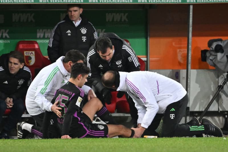 Bayern Munich's Aleksandar Pavlovic receives medical treatment after an injury during the German Bundesliga soccer match between FC Augsburg and Bayern Munich at the WWK-Arena. Sven Hoppe/dpa