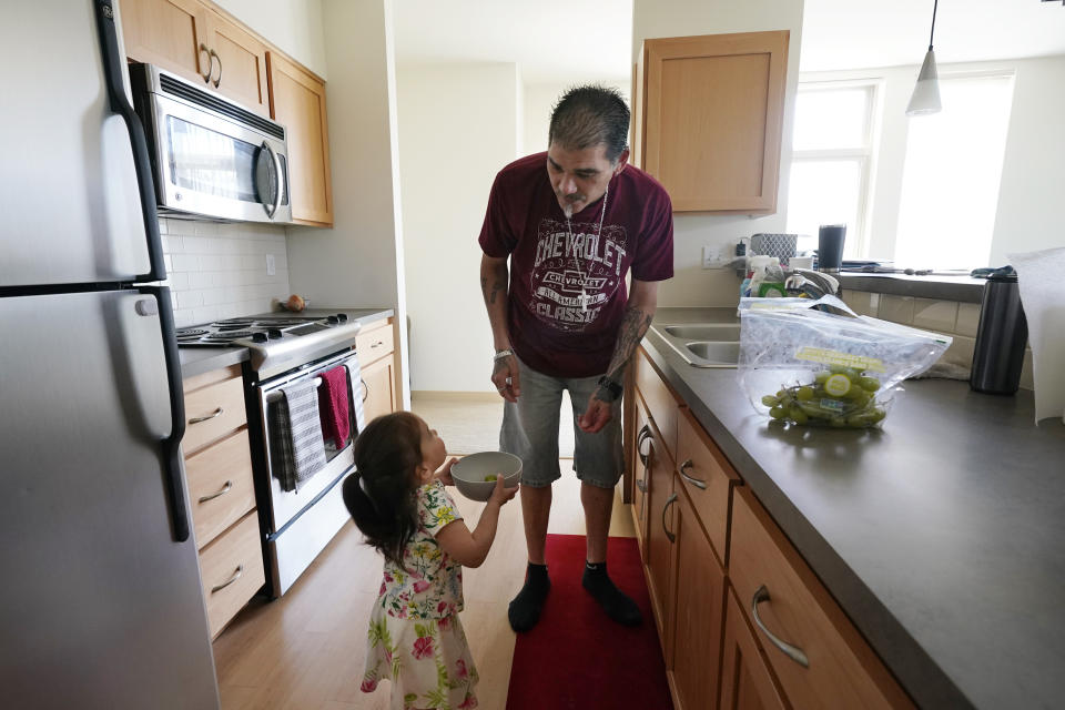 Leroy Pascubillo prepares a snack of grapes for his daughter, who was born addicted to heroin and placed with a foster family at birth, May 10, 2021, in Seattle. Pascubillo, who had used drugs for the better part of four decades, was in a court-ordered in-patient drug rehab program when the pandemic first hit. (AP Photo/Elaine Thompson)