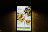 FILE - In this Feb. 20, 2018, file photo shows the Uber Eats app on an iPhone in Chicago. The growing options for outsourcing meal planning, grocery shopping and cooking can be called time-saving blessings or culture-destroying curses. In the end, they're probably a complicated mix of both. (AP Photo/Charles Rex Arbogast, File)