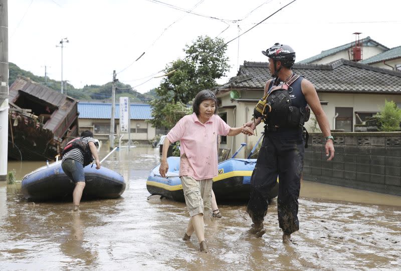 Un rescatista ayuda a los residentes locales en una zona inundada causada por una fuerte lluvia a lo largo del río Kuma en Hitoyoshi, prefectura de Kumamoto, en el sur de Japón, el 4 de julio de 2020