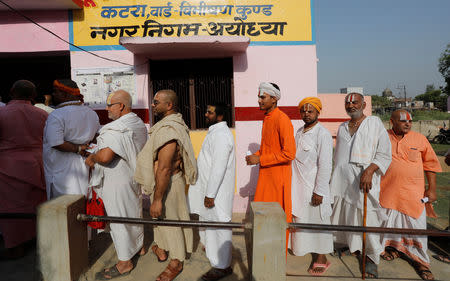 Hindu holy men stand in a queue outside a polling station to caste their vote during the fifth phase of the general election in Ayodhya, May 6, 2019. REUTERS/Pawan Kumar