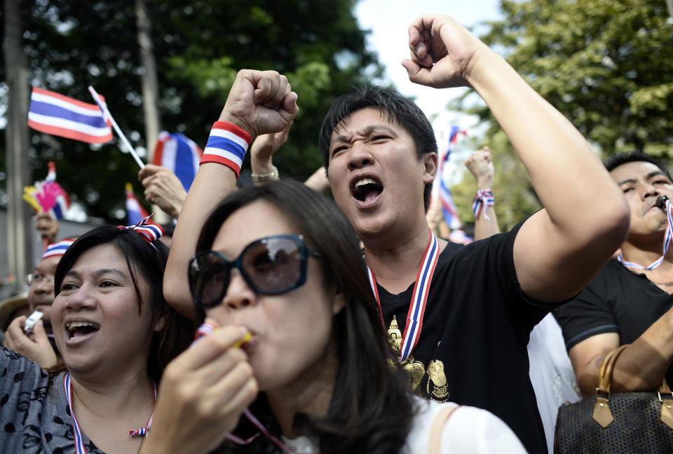 Anti-government protesters blow whistles and chant slogans during a demonstration in central Bangkok