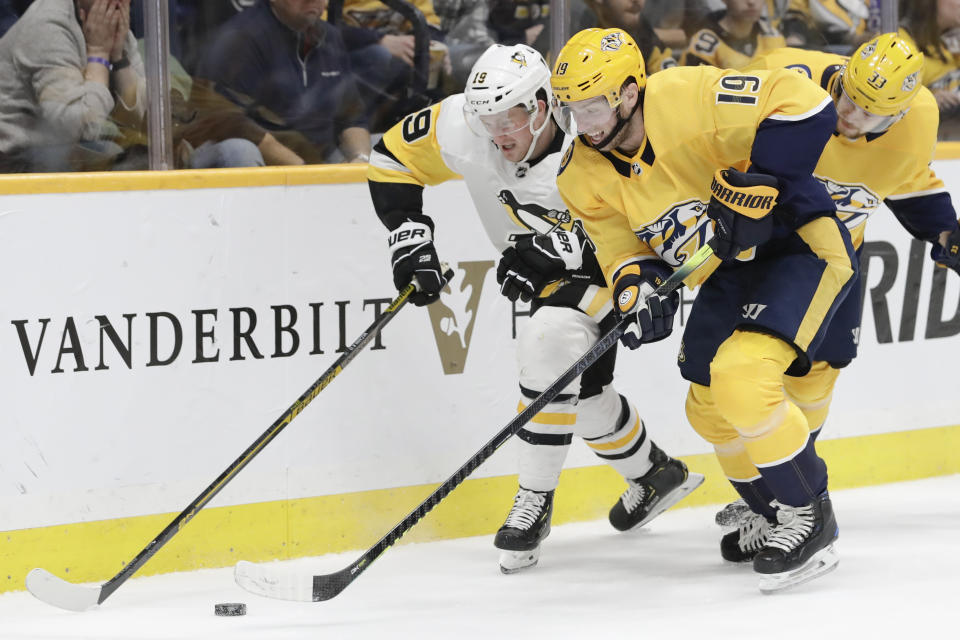 Pittsburgh Penguins center Jared McCann, left, and Nashville Predators center Calle Jarnkrok, of Sweden, right, compete for the puck during the second period of an NHL hockey game Friday, Dec. 27, 2019, in Nashville, Tenn. (AP Photo/Mark Humphrey)