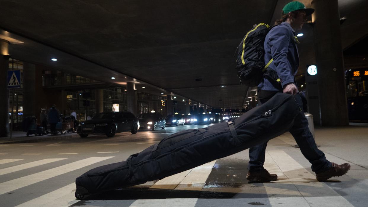  Traveler carrying skis to airport at night -. 