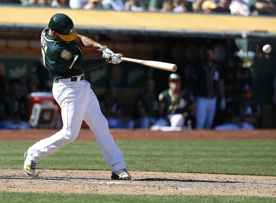 Oakland Athletics' Marcus Semien hits a double to drive in three runs against the Los Angeles Angels during the sixth inning of a baseball game in Oakland, Calif., Thursday, Sept. 20, 2018. (AP Photo/Tony Avelar)