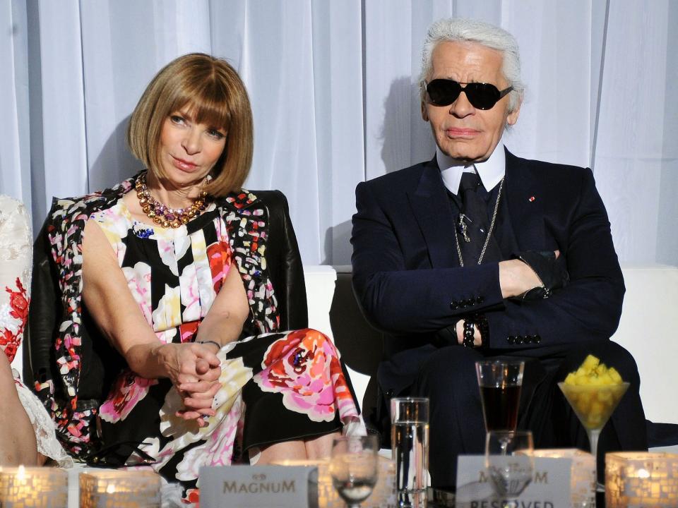 Anna Wintour and Karl Lagerfeld sit on a bench.