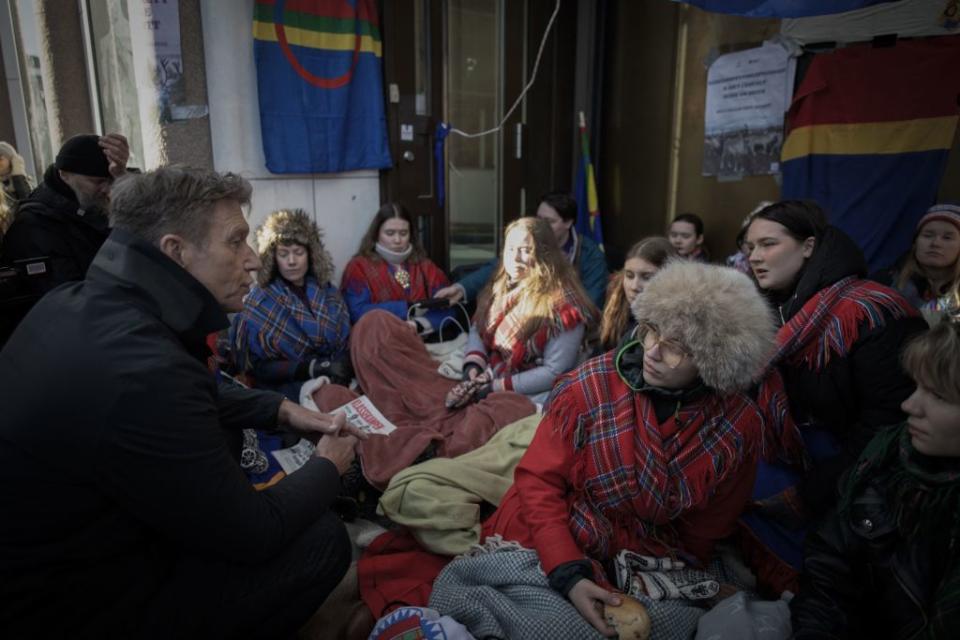Norway's Oil and Energy Minister Terje Aasland speaks to young climate protesters from the "Nature and Youth" and "Norwegian Samirs Riksforbund Nuorat" groups who block the entrance of Norway's Energy Ministry on February 28, 2023.<span class="copyright">Oliver Morin—AFP/Getty Images</span>