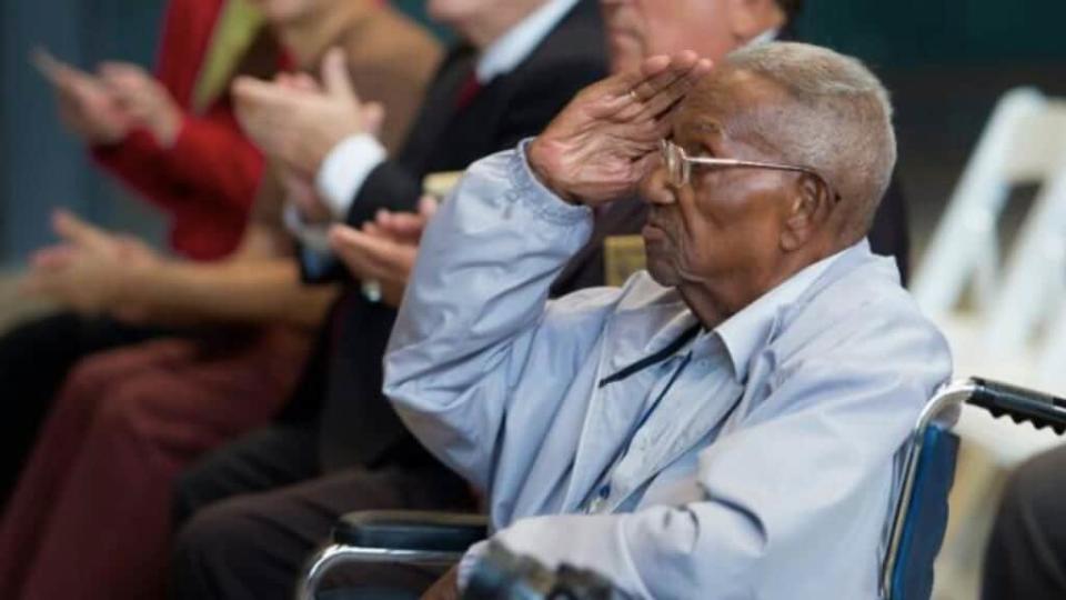 World War II veteran Lawrence Brooks, 107, salutes the speakers honoring him from the stage at The National World War II Museum in New Orleans on Monday, Sept. 12, 2016, during a birthday celebration for Brooks. (Chris Granger/NOLA.com The Times-Picayune via AP)