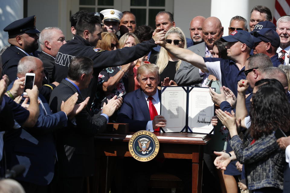 President Trump holds up the signed bill permanently reauthorizing the September 11th Victim Compensation Fund in the Rose Garden of the White House on Monday. (AP Photo/Alex Brandon)