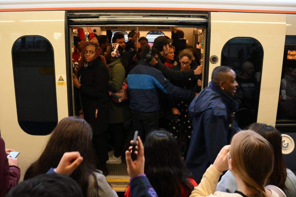 Commuters board a crowded train at Stratford Station (AFP via Getty Images)