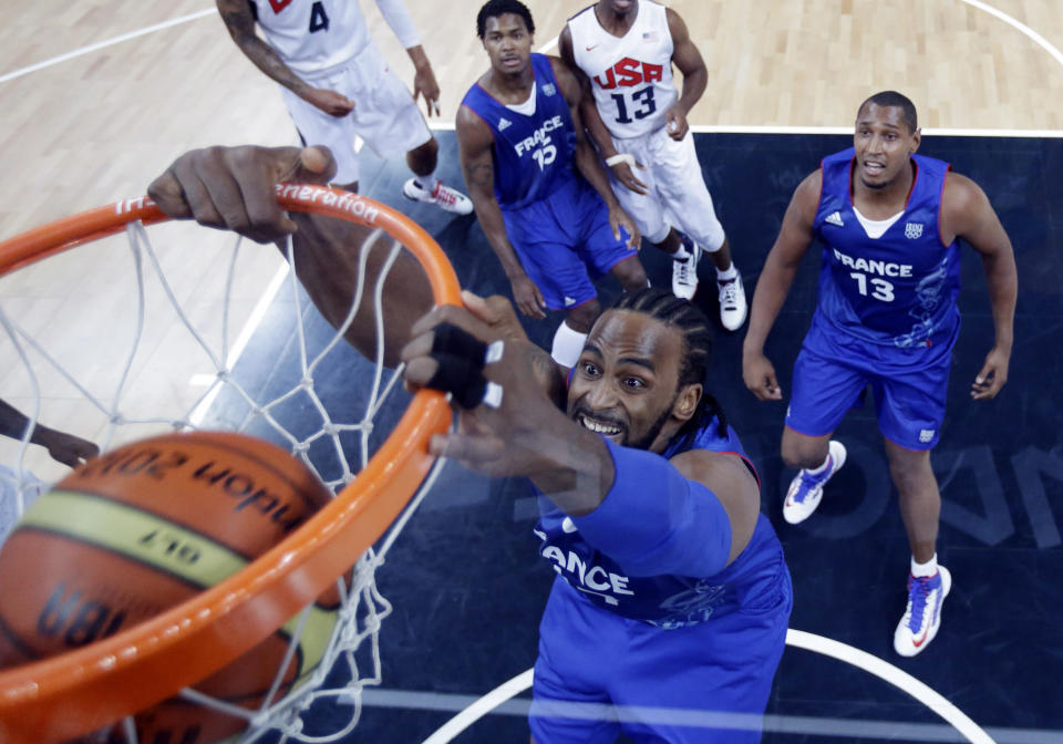 LONDON, ENGLAND - JULY 29: France's Ronny Turiaf scores as teammates Boris Diaw and Mickael Gelabale look on during the first half of a preliminary men's basketball game against the USA on Day 2 of the London 2012 Olympic Games at the Basketball Arena on July 29, 2012 in London, England. (Photo by Eric Gay - IOPP Pool /Getty Images)