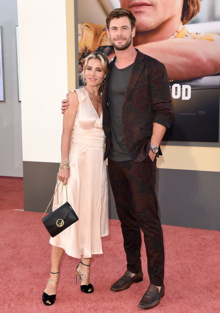 as they pose on the red carpet together, Elsa leans her head on Chris's shoulder, and he puts his arm around her