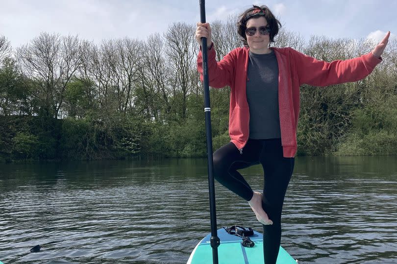 Sofie Jackson tries to do the 'tree' yoga position on a paddleboard at Kelsey Lakes