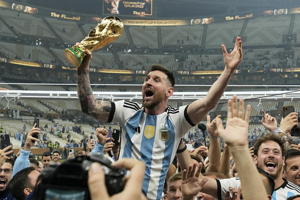 FILE - Argentina's Lionel Messi celebrates with the trophy in front of the fans after winning the World Cup final soccer match between Argentina and France at the Lusail Stadium in Lusail, Qatar, Sunday, Dec. 18, 2022. Lionel Messi has been named FIFA’s best men’s player after moving to Inter Miami and leading the team to a little-known Leagues Cup title, all while single-handedly elevating soccer’s relevance in the United States. The 36-year-old Argentina star on Monday was selected over Kylian Mbappe and Erling Haaland — the same pair he beat for his eighth Ballon d’Or award last October. (AP Photo/Martin Meissner, File)