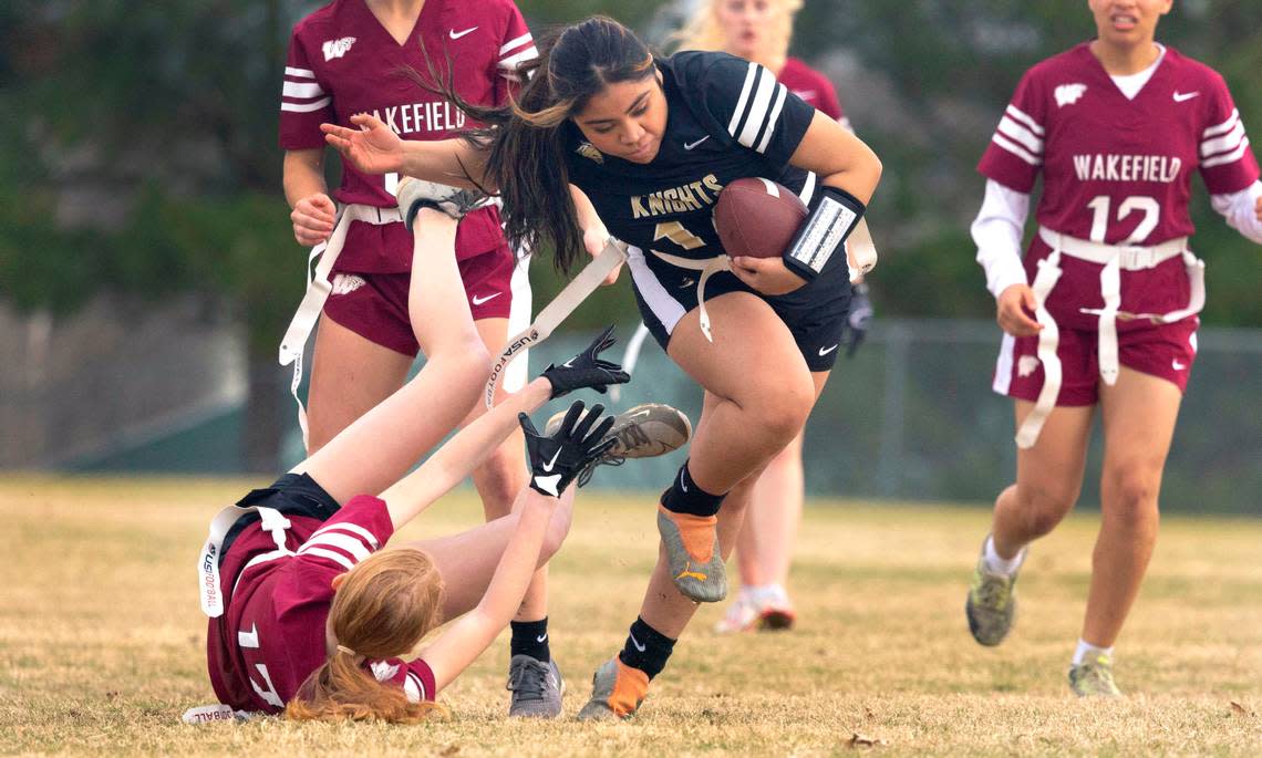 Knightdale High School’s Amy Gomez (14) gets by Wakefield 17 during a flag football scrimmage at Heritage High School in Wake Forest, N.C., Wednesday, Jan. 24, 2024.
