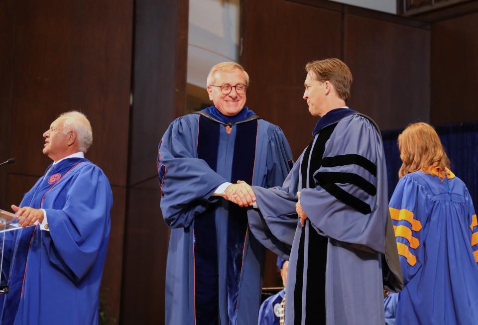 Ben Sasse, UF's new president, shakes hands with Kent Fuchs, president emeritus, during his inauguration on Nov. 2, 2023 at the University of Florida Auditorium in Gainesville, Florida.