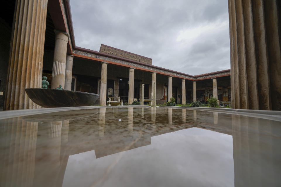 The 'peristylium', or courtyard, is reflected in the water contained in one of the basins that adorn it, in the Ancient Roman Domus Vettiorum, House of Vettii, in the Pompeii Archeological Park, near Naples, southern Italy, Wednesday, Dec. 14, 2022. One of Pompeii's most famous and richest domus, which contains exceptional works of art and tells the story of the social ascent of two former slaves, is opening its doors to visitors Wednesday, Jan. 11, 2023 after 20 years of restoration. (AP Photo/Andrew Medichini)