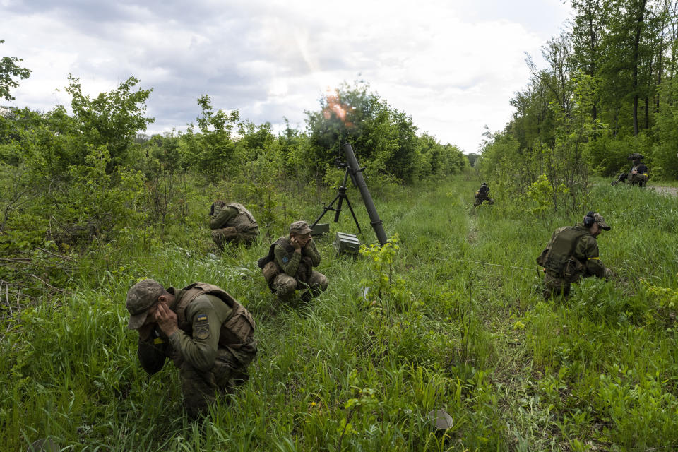 Militares ucranianos acompañados por miembros de la legión extranjera lanzan morteros contra posiciones rusas el martes 17 de mayo de 2022 en la región oriental de Járkiv, Ucrania. (AP Foto/Bernat Armangue)