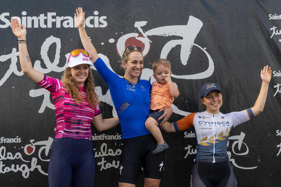 Tulsa Tough women's omnium winner (center) Sam Schneider of L39ION of LA and her son Henry celebrate with second-placed Olivia Cummins (DNA Pro) and third-placed Katherine Sarkisov (Cynisca Cycling)