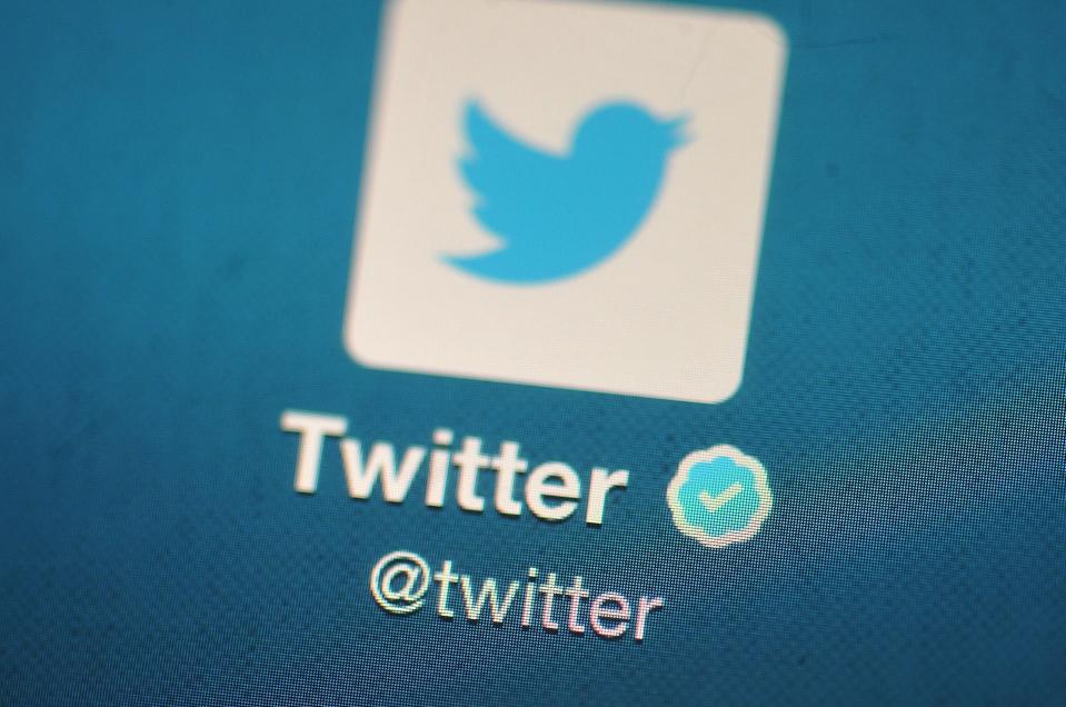 In this photo illustration, The Twitter logo is displayed on a mobile device.