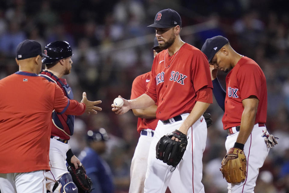 Boston Red Sox pitcher Matt Barnes hands the ball to manager Alex Cora after the Tampa Bay Rays scored three runs on a single by Francisco Mejia during the ninth inning of a baseball game at Fenway Park, Tuesday, Aug. 10, 2021, in Boston. (AP Photo/Charles Krupa)