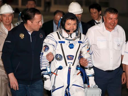 The International Space Station (ISS) crew member Oleg Kononenko of Russia (C) walks to board the Soyuz TMA-17M spacecraft at the Baikonur cosmodrome, Kazakhstan, July 23, 2015. REUTERS/Yuri Kochetkov/Pool