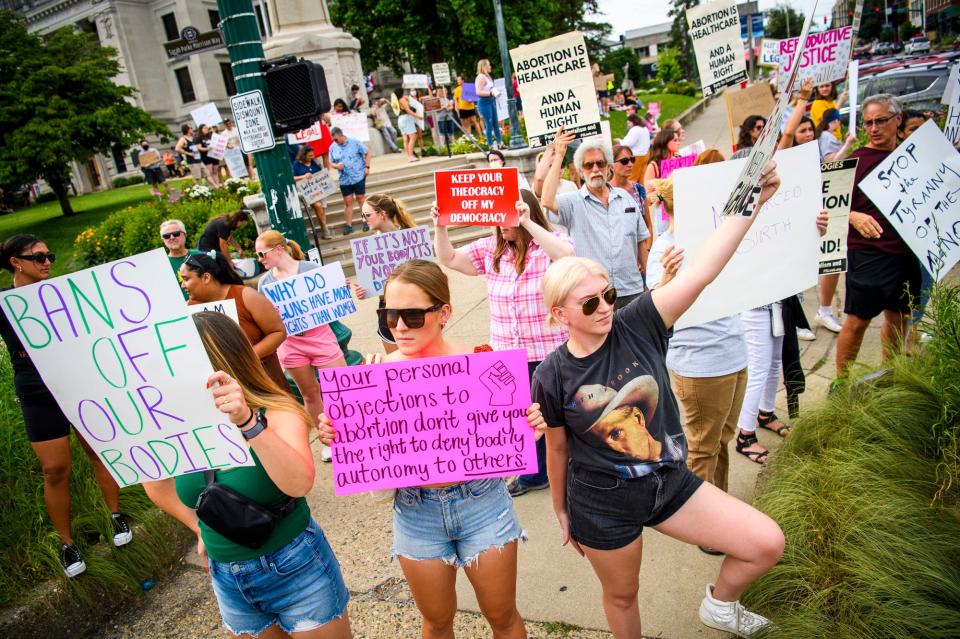 Kacey Henning, left, Megan Freveletti, middle, and Elli Schank, right,  hold signs as they voice their opinion of the overturning of the Roe versus Wade decision by the Supreme Court at the Monroe County courthouse on Friday, June 24, 2022.