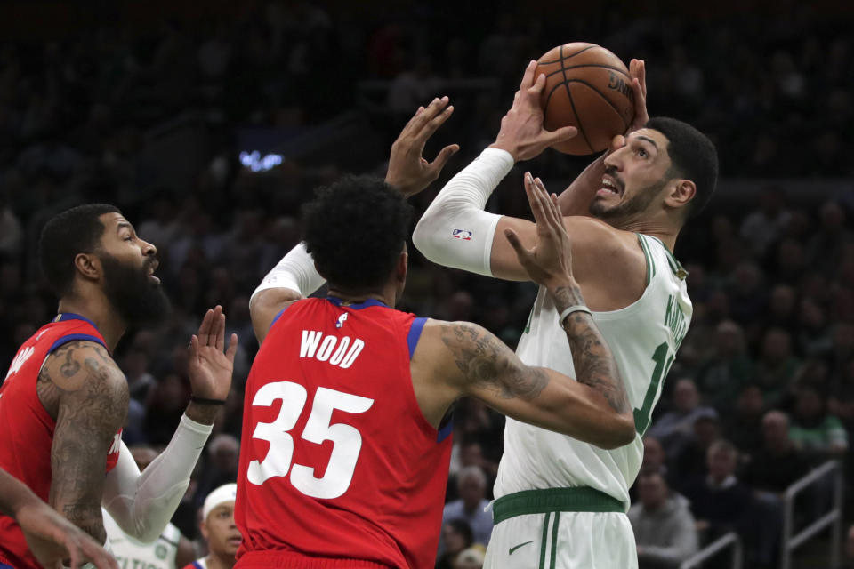 Boston Celtics center Enes Kanter, right, is pressured by Detroit Pistons forwards Christian Wood (35) and Markieff Morris, left, during the first half of an NBA basketball game in Boston, Wednesday, Jan. 15, 2020. (AP Photo/Charles Krupa)