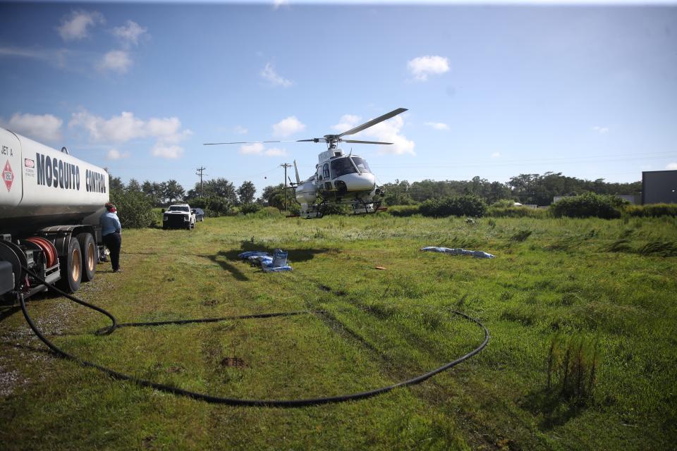 A Lee County Mosquito Control District helicopter lands during a mosquito treatment operation. The biting bugs, some of which carry disease, have exploded in numbers since Hurricane Ian.