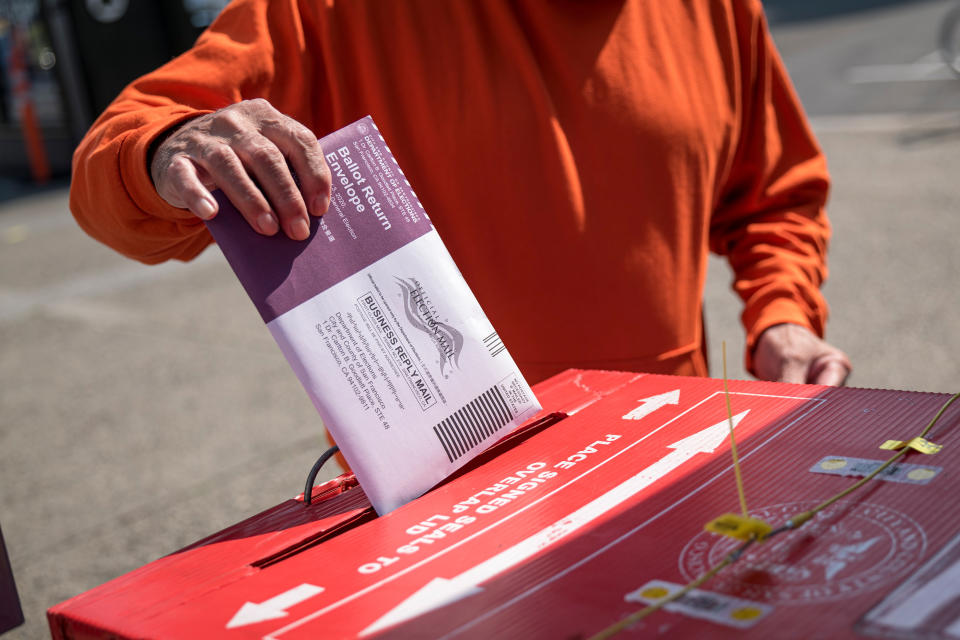 A resident drops a ballot inside a ballot box at an early voting polling location for the 2020 Presidential election in San Francisco, California, U.S., on Tuesday, Oct. 6, 2020. (David Paul Morris/Bloomberg via Getty Images)