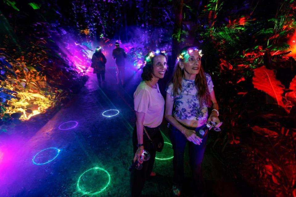 Tanya Acosta and Susan Coccetti, left to right, pose as they walk through the Rainbow Rainforest at NightGarden.